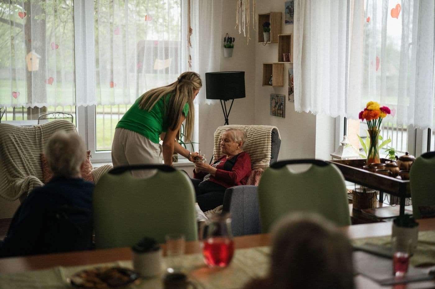 A care worker with residents in a care home lounge
