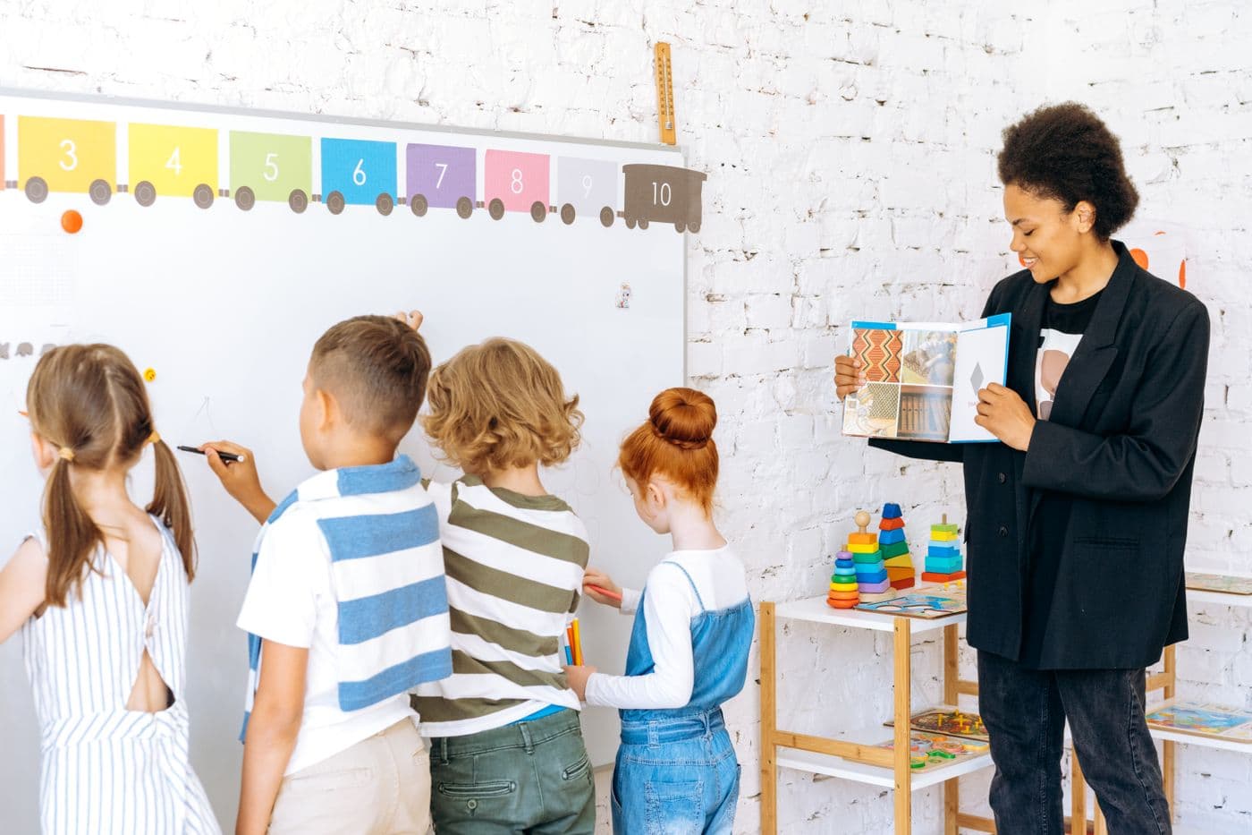 A teacher with young pupils at a classroom board